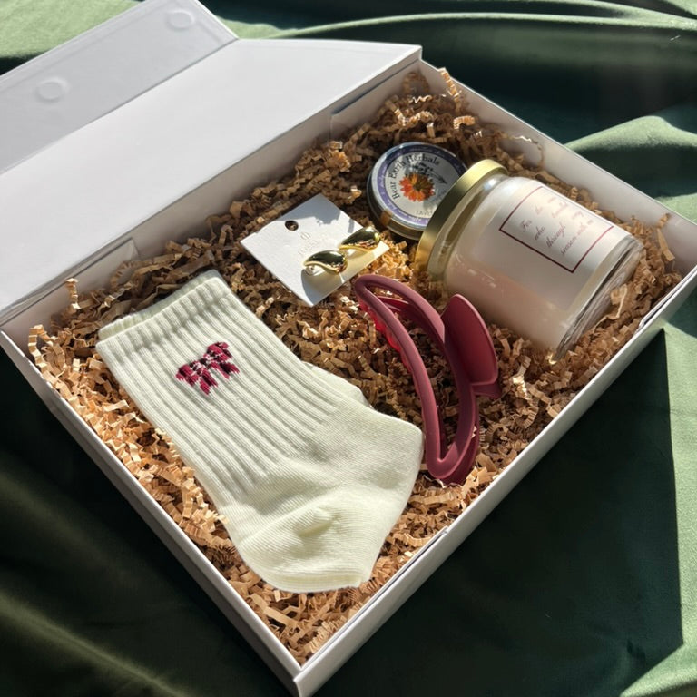 Bridesmaid proposal gift set with socks, custom candle, and high quality goods in a chic gift box.