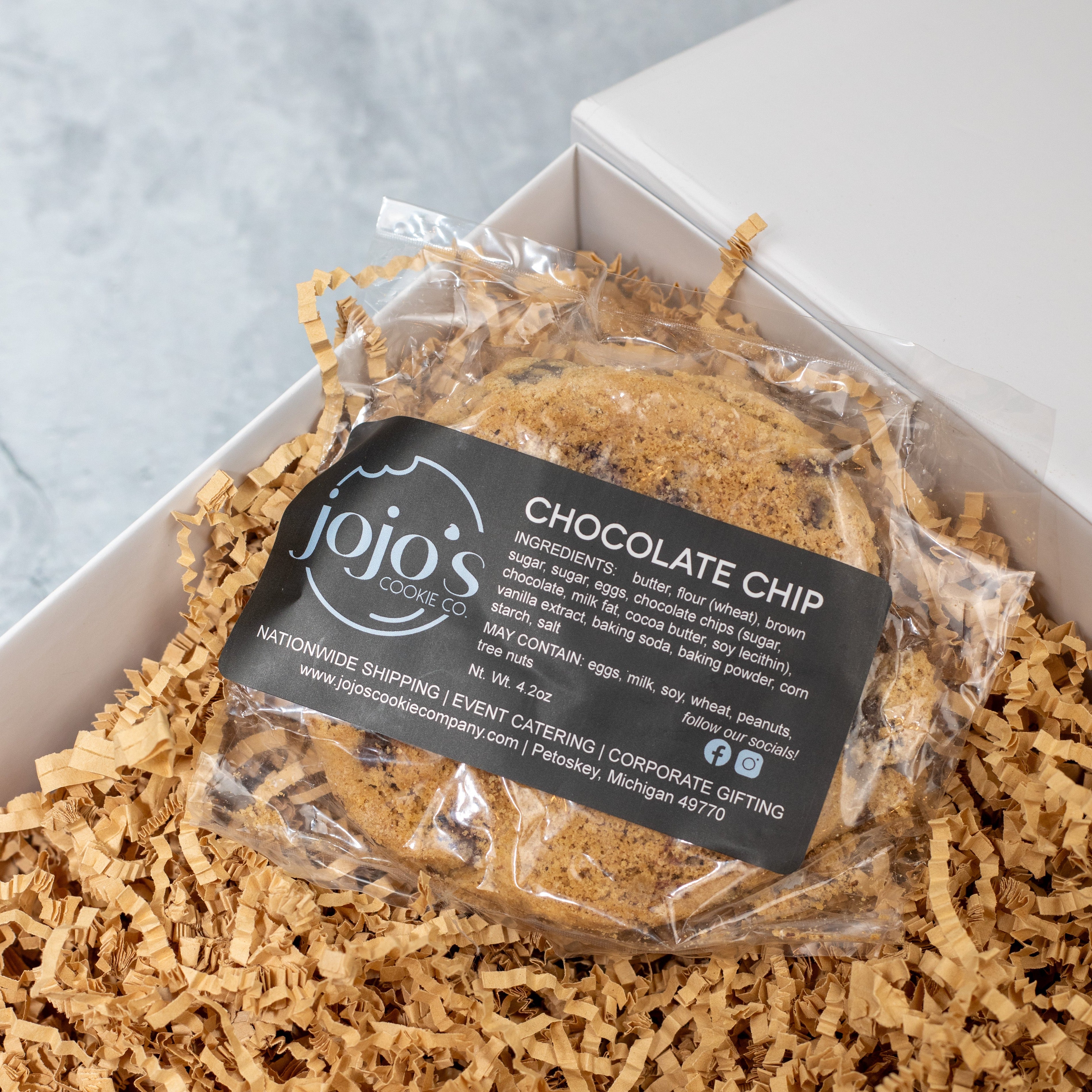Packaged chocolate chip cookies with a 'jojo's cookies' label on a light background